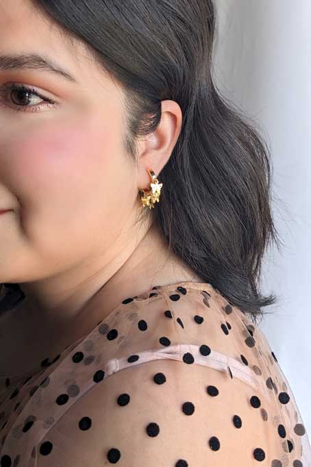 model wearing Gold hoops with butterflies 