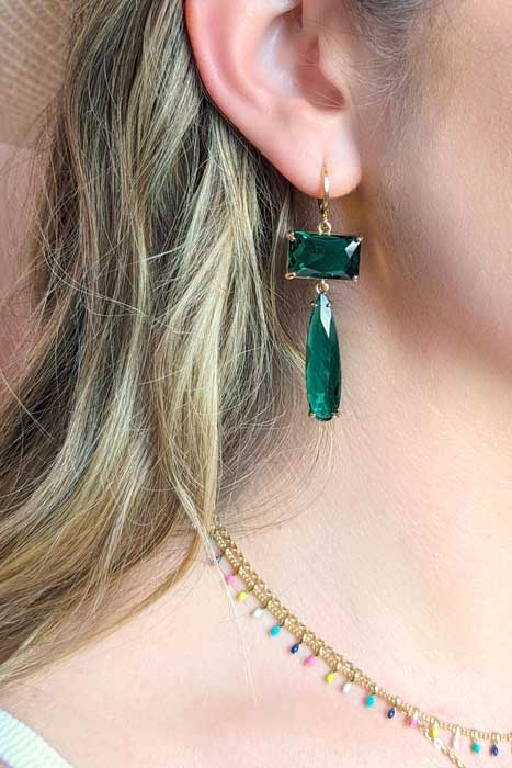 Statement green and gold earrings on a model