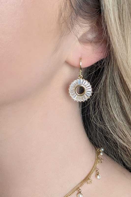 model wearing Gold round earring covered with CZ