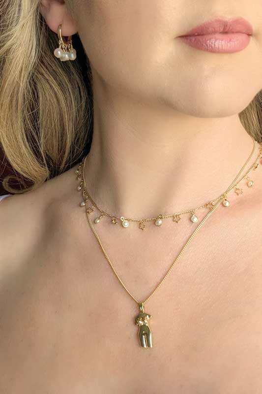 pearl and star gold chain necklace on a model. She's wearing it with a goddess pendant necklace
