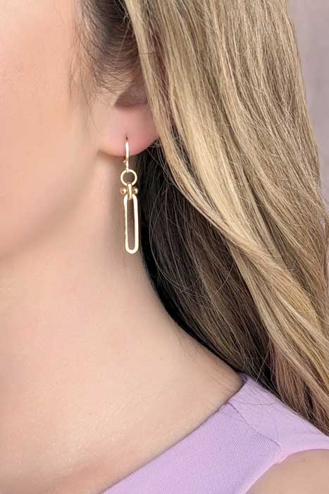 Gold minimalist link earrings on a model