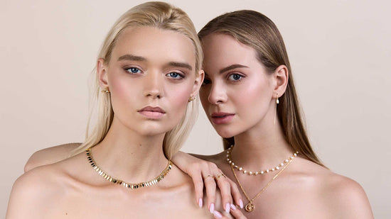 Two girls looking at the camera wearing earrings and necklaces