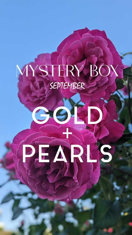 Floral background and announcement that September's mystery box is gold and pearls