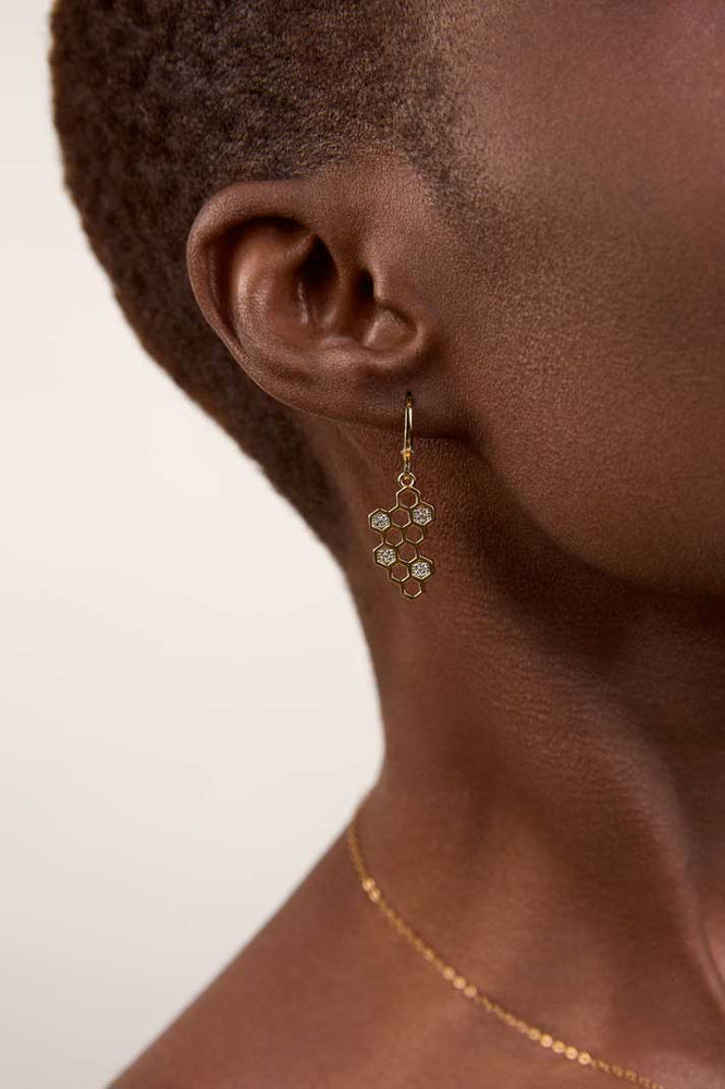 
                  
                    girl wearing a gold honeycomb earrings
                  
                