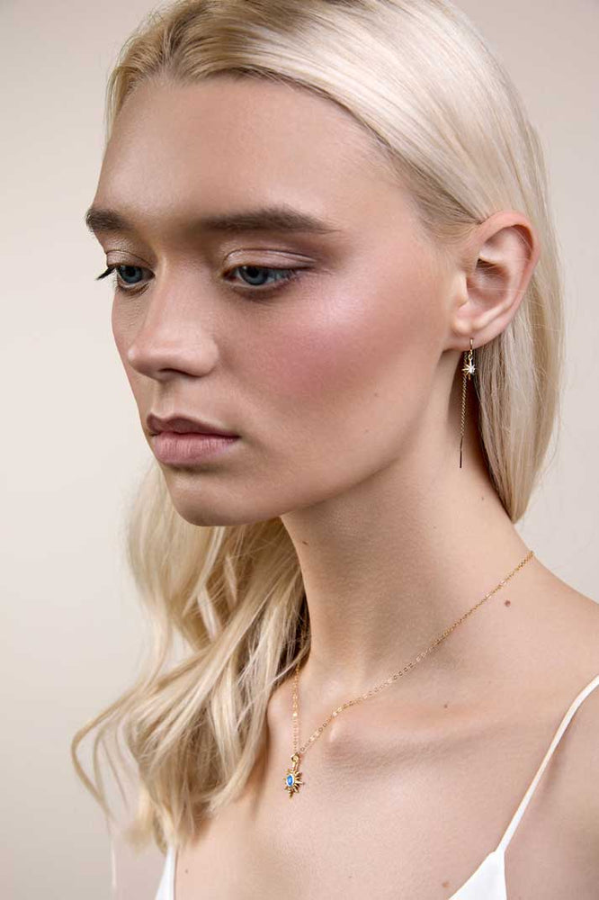 
                  
                    Girl wearing dainty gold threader earrings with stars
                  
                