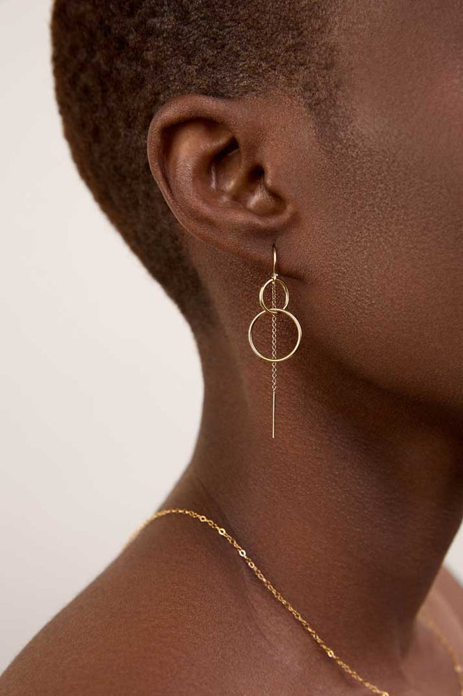 
                  
                    Girl wearing double circle gold threaders
                  
                