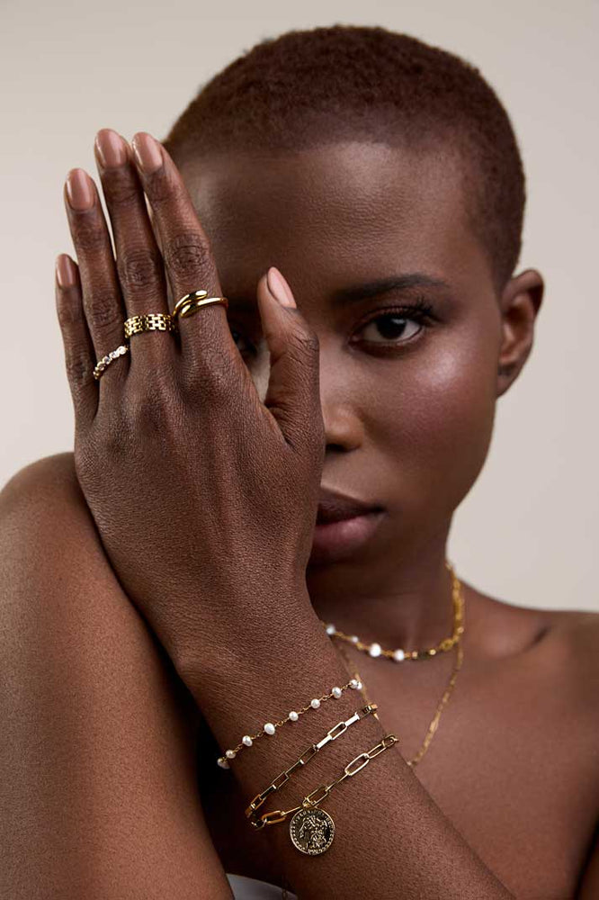 
                  
                    Girl with hand forward wearing layered rings and bracelets
                  
                