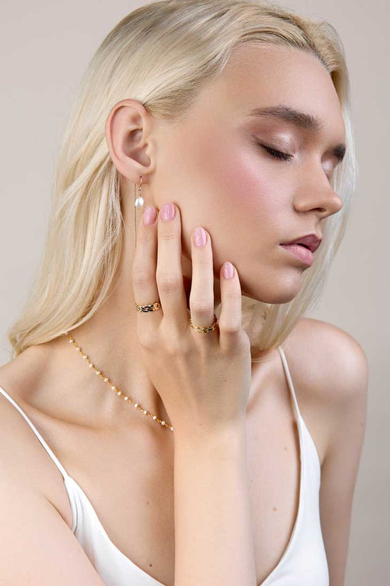 Girl with pearl earrings and chain style rings