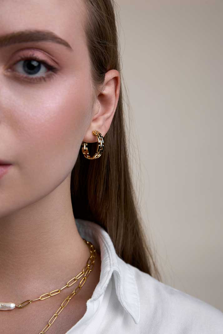 Half a face of a girl with hair down wering gold hoops