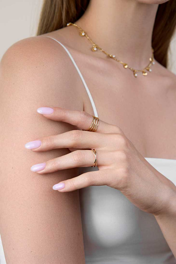 Hand of a girl wearing two layered style gold rings