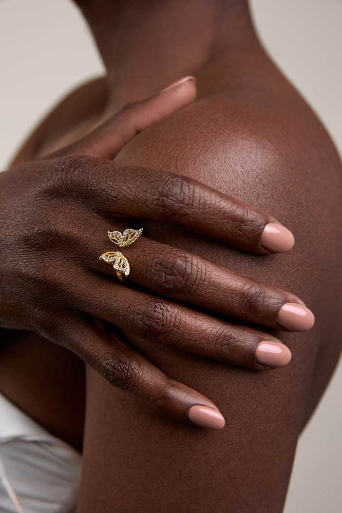 
                  
                    Hand on a shoulder wearing a gold butterfly ring
                  
                