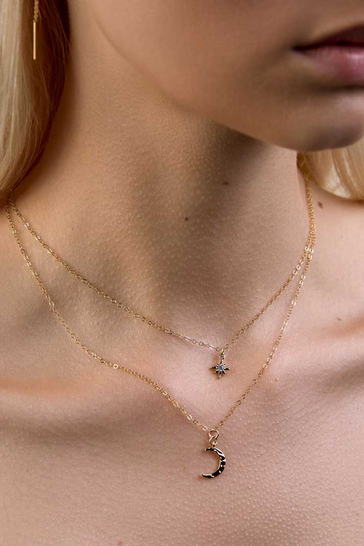 Neck showing dainty gold star and moon necklaces